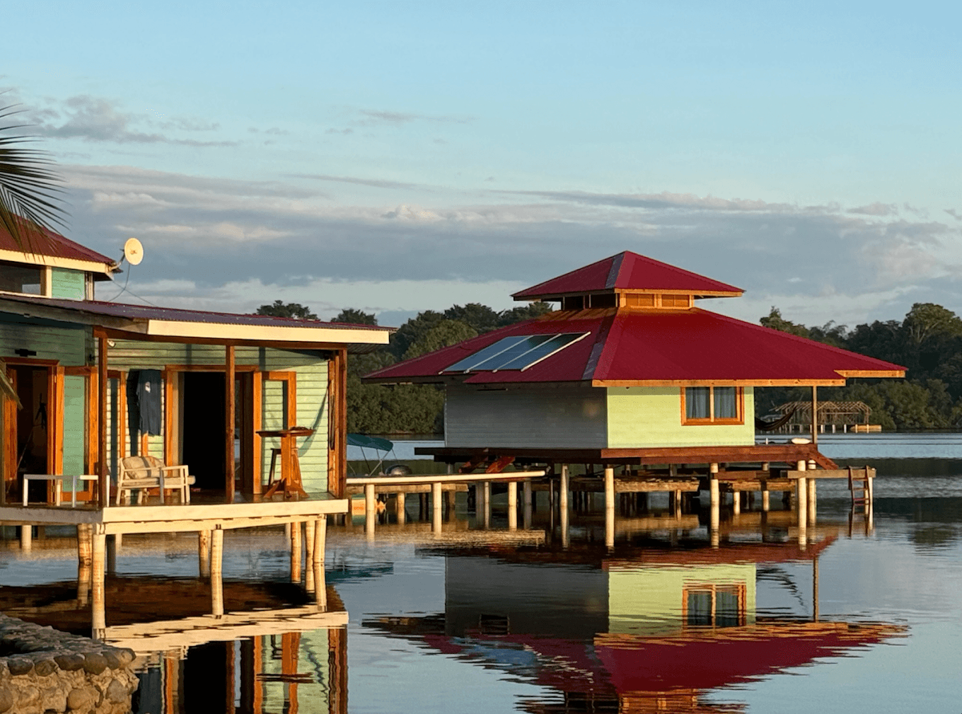 Premium Deluxe Sea View Cabana at golden hour - bright sky blue overwater villa at Dolphin Blue Paradise eco-resort, Bocas del Toro, Panamá