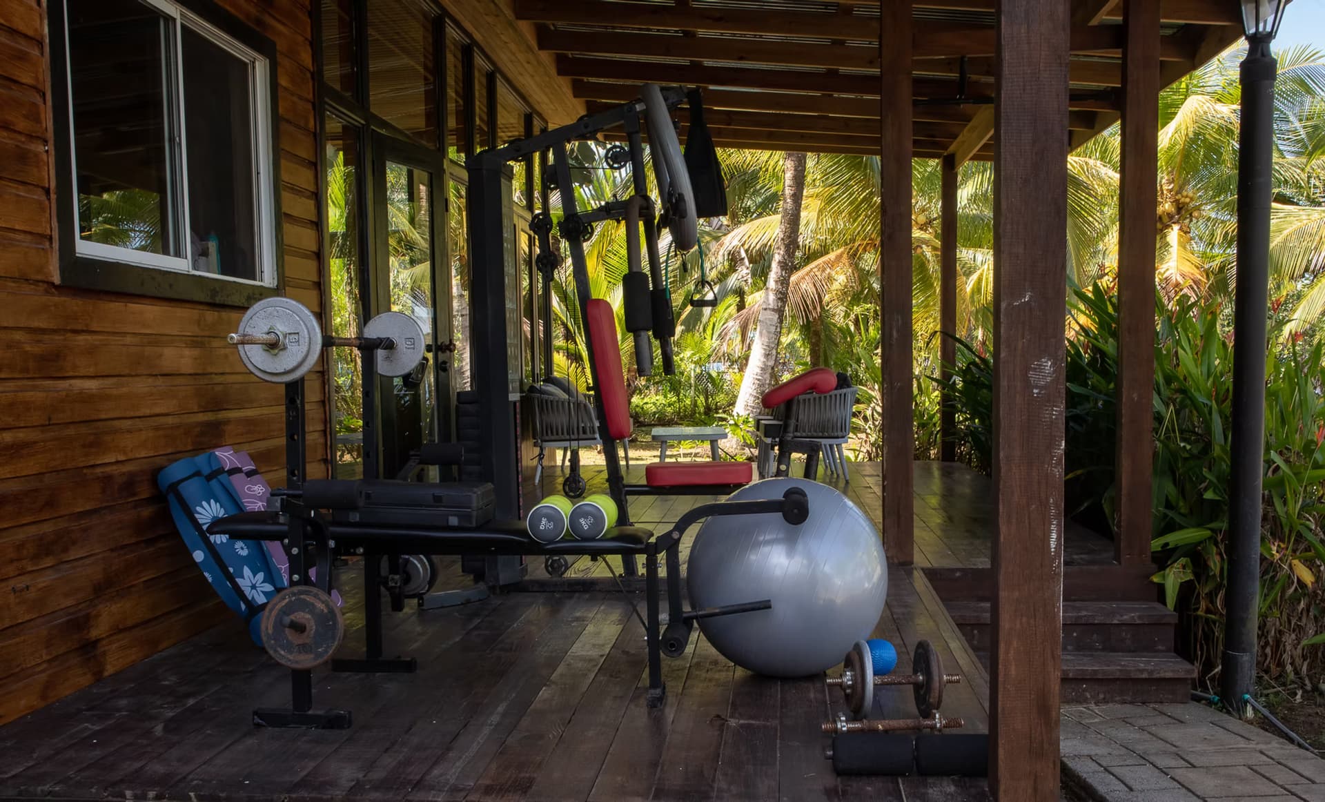 Salon Azul outdoor workout area and gym at Dolphin Blue Paradise, Bocas del Toro - patio with weights, dumbbells, fitness ball, and yoga mats
