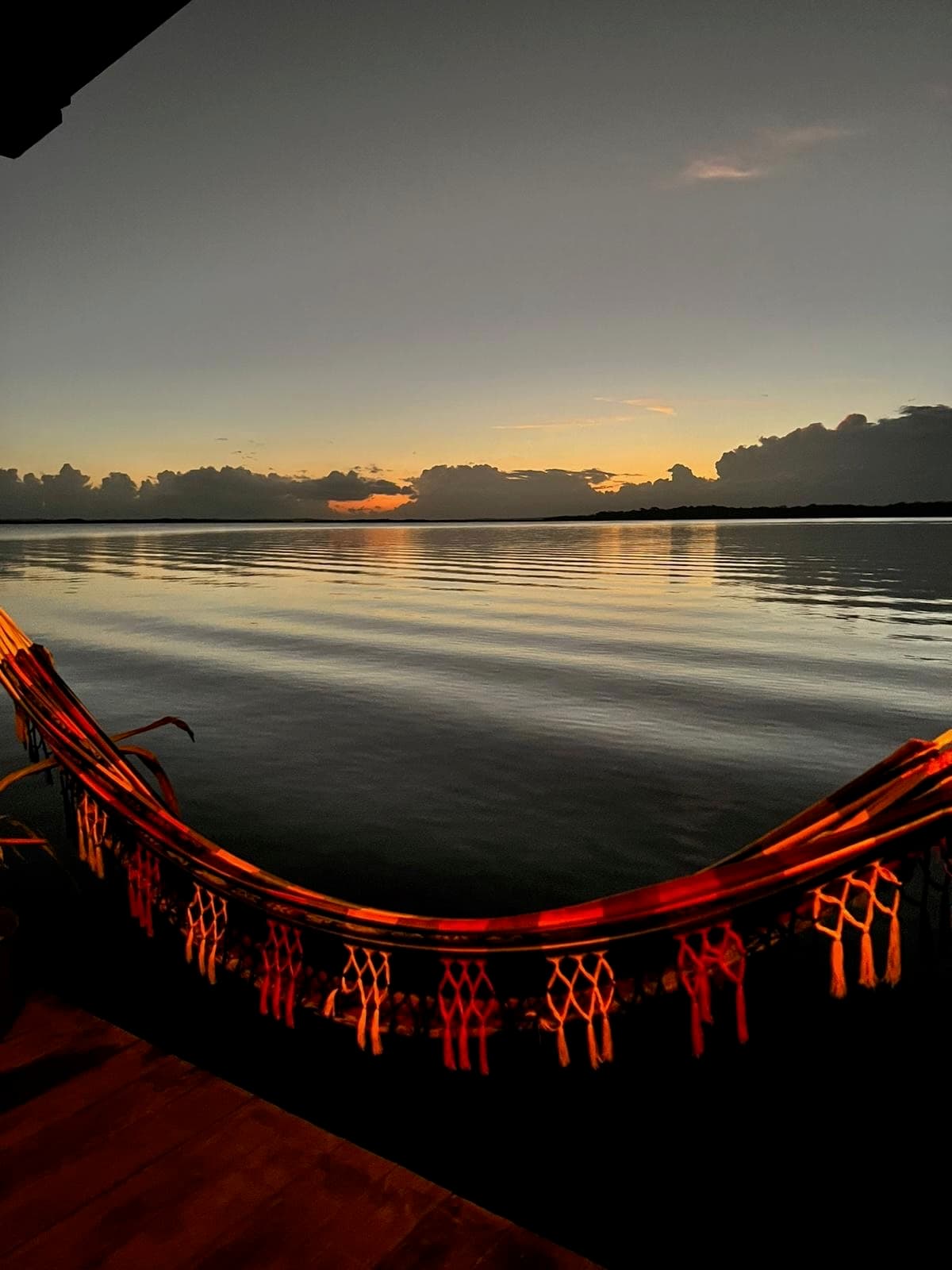 Sunset over Dolphin Bay with hammock on swim platform at Dolphin Blue Paradise, Bocas del Toro - golden hour relaxation