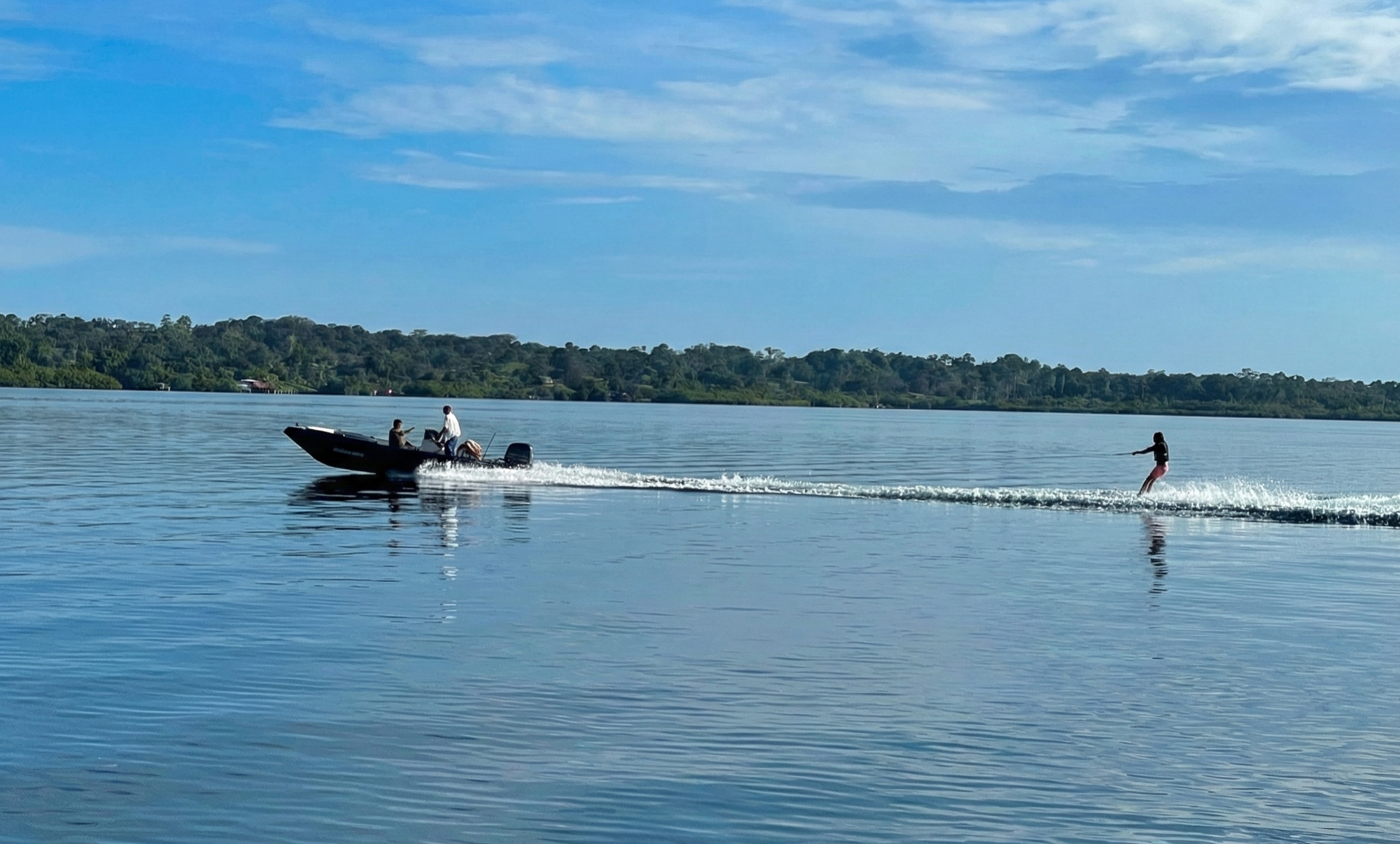 Lancha cruzando las aguas tranquilas de Bahía Delfines en Bocas del Toro