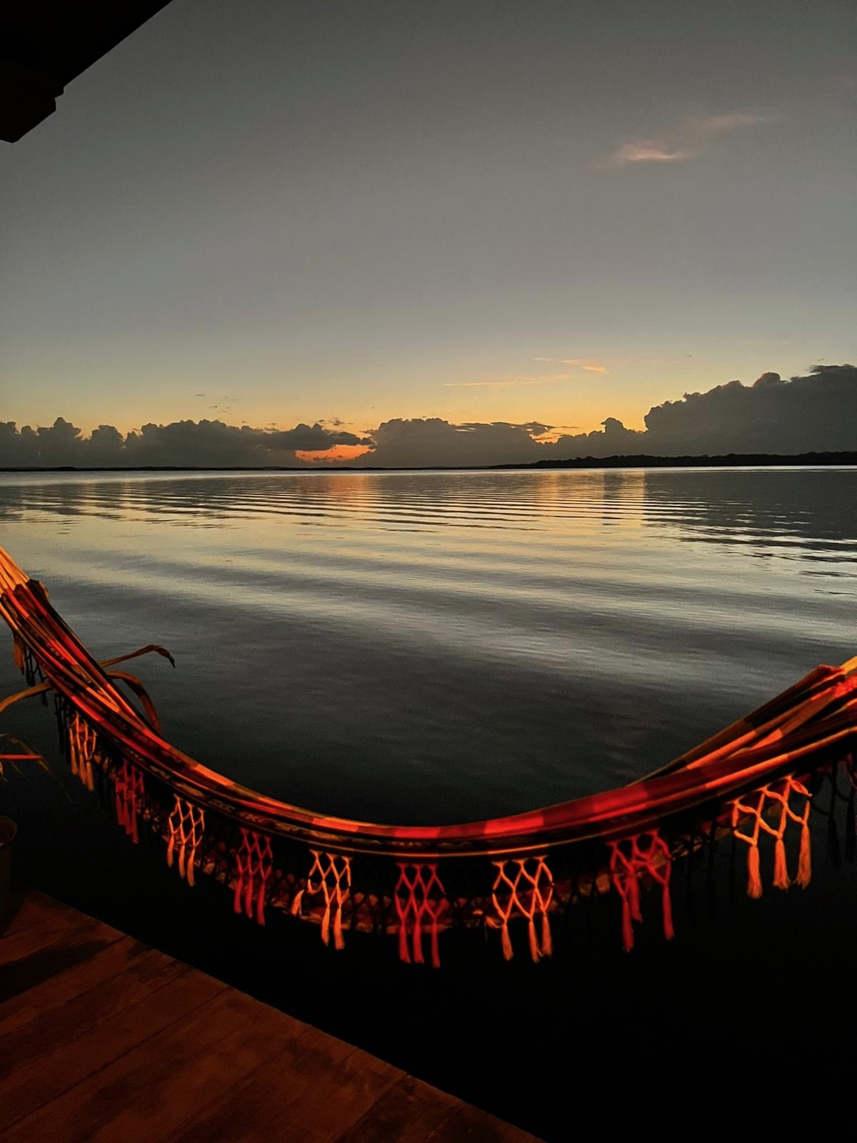 Sunset over Dolphin Bay with hammock on swim platform at Dolphin Blue Paradise, Bocas del Toro - golden hour relaxation